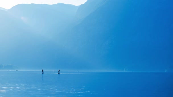 Cinemagraph Footage Two People Stand Paddle Boarding Lake Blue Toned — Video Stock
