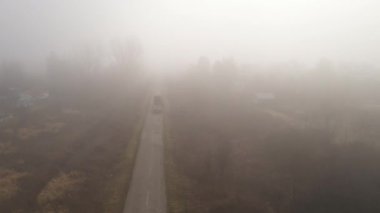 Sisli bir sabahta yolda boş karavanla kereste taşımak için hava görüntüsü, yüksek açı manzaralı.