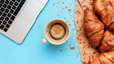 Coffee and croissants for messy breakfast in business office, top view flat lay, cinemagraph footage