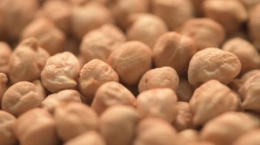 Pile of raw chickpea on turning plate, close up with selective focus