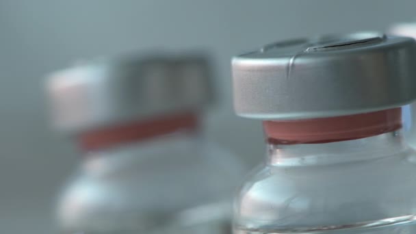 Covid 19ワクチンのコンセプトのための医療研究室で回転するワクチン瓶は 選択的な焦点で閉じます — ストック動画
