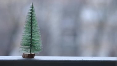 Küçük masa başı Noel ağacı, arka planında kar taneleri olan, seçici odaklı.