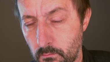 Contemplative pensive man with raised eyebrow looking at mirror and thinking, close up headshot portrait