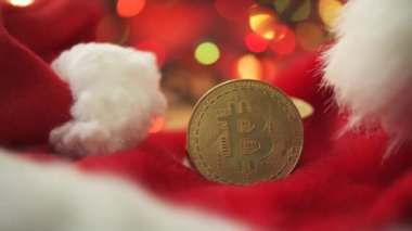Noel Noel süslemesi, bozuk para yığını ve Noel Baba şapkası olan bitcoin. Bokeh arka planda festival telli ışık, seçici odaklı.
