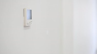 Kadın el, ev ısıtma ve soğutma sistemi kontrol ünitesinin düğmesine basıyor, seçici odak ile yakın plan