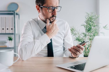 İşçi iletişimi için dahili SMS kullanan yönetici, ofiste cep telefonu olan iş adamı, seçici odaklanma