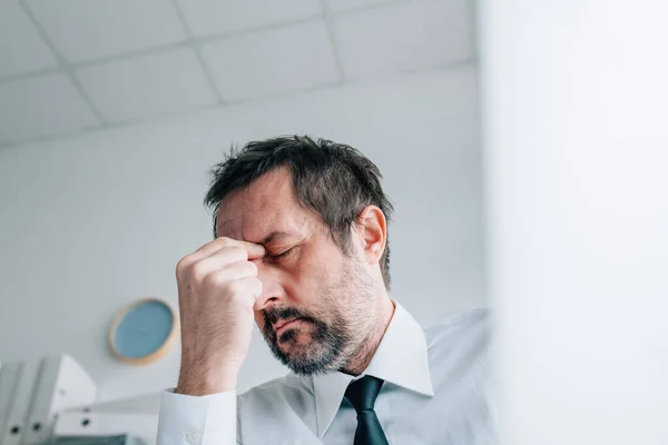 ビジネスオーナー頭痛の概念 オフィスで痛みを伴う片頭痛を持つビジネスマン 選択的な焦点 — ストック写真