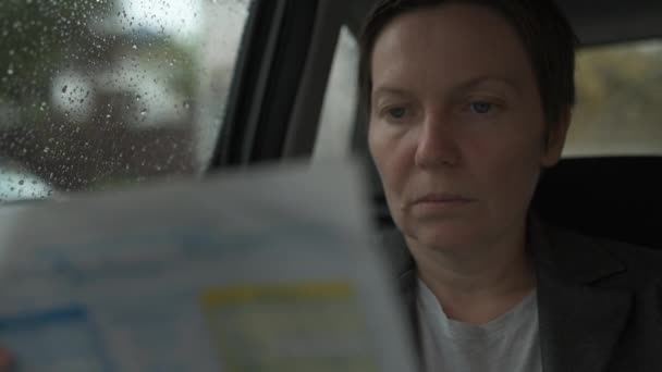 Mujer Negocios Leyendo Informe Negocios Asiento Trasero Coche Durante Lluvia — Vídeos de Stock