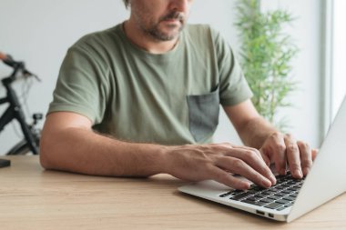 Uzaktan çalışma, seçici odak yaparken ev ofisinde dizüstü bilgisayar klavyesi yazan telekomünikatör