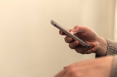 Oturma odasında iletişim kurmak için akıllı telefon kullanan kadın ellerinin kapatılması, seçici odaklanma