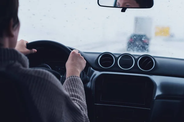 在暴风雪中驾驶汽车的妇女 有选择地从乘客的角度出发 — 图库照片
