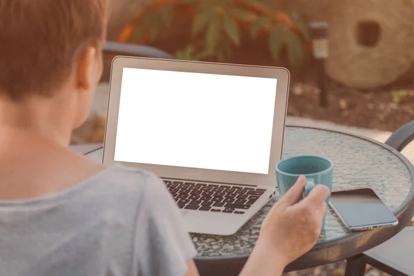 女性フリーランスデジタルノマド仕事休暇 ノートパソコンのモックアップ画面を見て コーヒーを飲む 選択的な焦点 — ストック写真