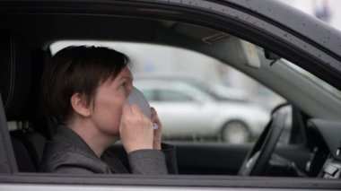 Covid-19 salgını sırasında arabada koruyucu yüz maskesi takan kadın aynaya bakıyor, el kamerası görüntüsü seçici odaklanma