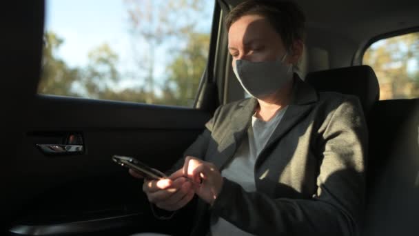 Geschäftsfrau Tippt Sms Auto Während Sie Eine Gesichtsmaske Für Die — Stockvideo