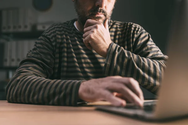 Maschio Adulto Contemplativo Casuale Che Utilizza Computer Portatile Interni Scuri — Foto Stock