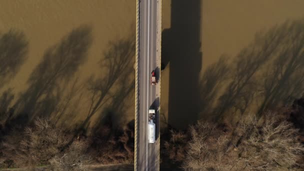 川を渡って橋を渡るさまざまな車両 秋の午後の空中ビュートップダウンドローン映像 — ストック動画