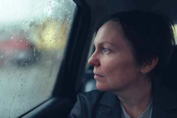 雨の日に窓の外を見てタクシーの車のビジネス女性 選択的フォーカス — ストック写真