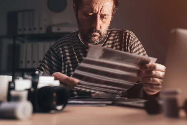 Photographer Reviewing Old Analog Camera Negative Filmstrip His Workplace Selective — Stock Photo, Image