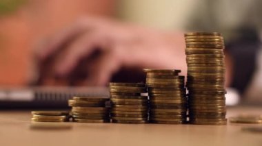 Ev bütçesi hesaplaması, arka planda adamlı para desteleri dizüstü bilgisayarda çalışıyor, seçici odaklanma