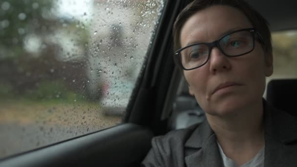 Zamartwiona Bizneswoman Okularami Czekająca Samochodzie Wyglądająca Przez Okno Podczas Deszczu — Wideo stockowe