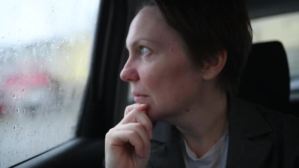 雨の日に窓の外を見るタクシーの車の中で魅力的なビジネス女性 選択的な焦点 — ストック動画