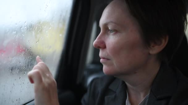 雨の日に窓にハート型を描くタクシーカーのビジネス女性 選択的フォーカス — ストック動画