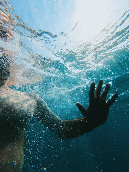泡と泡で海の水に泳いでいる男性の水中ショット — ストック写真