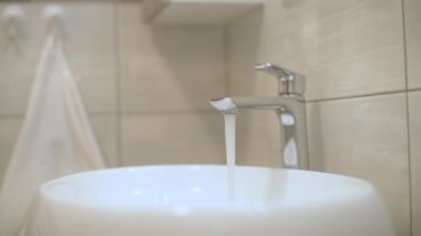 Banyodaki musluktan akan su, seçici odaklanma