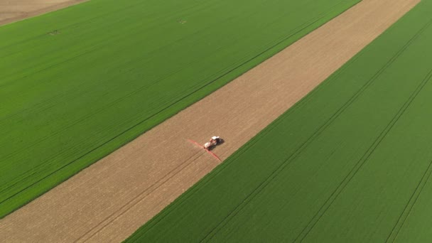 Luchtopname Van Landbouwtrekkers Met Aangebouwde Sproeier Bewerkt Veld Drone Pov — Stockvideo