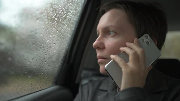 사업가 가비가 자동차 뒷좌석에서 전화로 이야기하는 선택적 — 비디오
