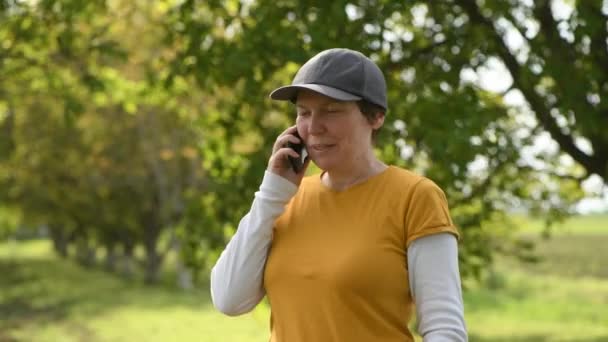 Γυναίκα Αγρότισσα Μιλάει Στο Κινητό Τηλέφωνο Βιολογικό Οπωρώνα Καρυδιάς Επιλεκτική — Αρχείο Βίντεο