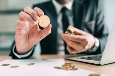 Bitcoin brokerage concept, businessman with cryptocurrency coins, selective focus