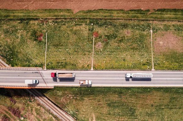 Widok Lotu Ptaka Dwóch Półciężarówek Dwóch Ciężarówek Autostradzie Wiaduktem Kolejowym — Zdjęcie stockowe