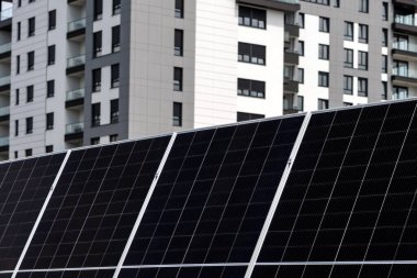 Arka planda apartman inşa eden güneş paneli fotovoltaik hücreleri, yenilenebilir ve alternatif enerji kavramı, seçici odaklanma