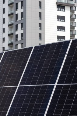 Arka planda apartman inşa eden güneş paneli fotovoltaik hücreleri, yenilenebilir ve alternatif enerji kavramı, seçici odaklanma