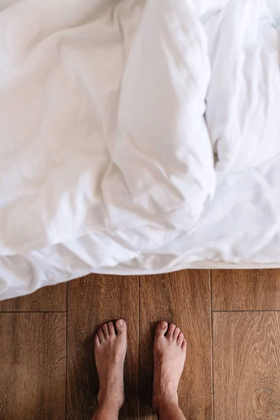 ベッドの前に立つ裸足の男性 トップビュー — ストック写真
