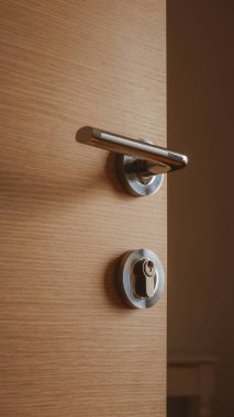 Orta yoğunluklu fiberboard yatak odası kapısının modern metal kapı kolu, seçici odaklı.
