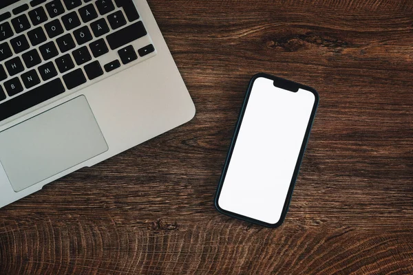 Ofis masasında boş beyaz dokunmatik ekran ve dizüstü bilgisayarı olan cep telefonu, iş iletişimi ve bağlantı konsepti için kopyalama alanı olan üst görünüm düzlüğü