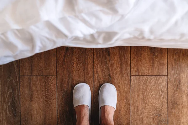 Männliche Füße Weißen Hotelpantoffeln Vor Dem Bett Stehend Von Oben — Stockfoto