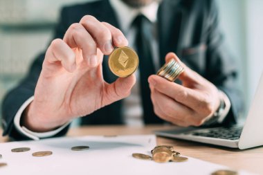 Ethereum kripto para tüccarı konsepti, madeni paraların ve arka planda çalışan iş adamlarının yakınlaştırılması, seçici odaklanma