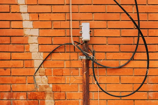 レンガの壁に乱雑なワイヤとケーブルを持つ外部屋外電話接続ジャンクションボックス — ストック写真