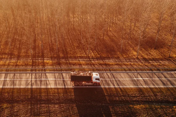 木立の秋の風景を介して運転ワゴンにロードされた廃棄物紙とトラックの空中ビュー ドローン写真 — ストック写真