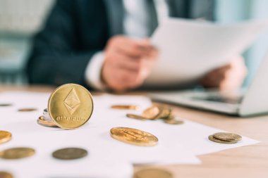 Ethereum kripto para tüccarı konsepti, madeni paraların ve arka planda çalışan iş adamlarının yakınlaştırılması, seçici odaklanma