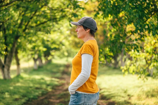 Porträt Einer Landarbeiterin Mit Orangefarbenem Shirt Und Truckermütze Walnussbaumgarten Selektiver — Stockfoto