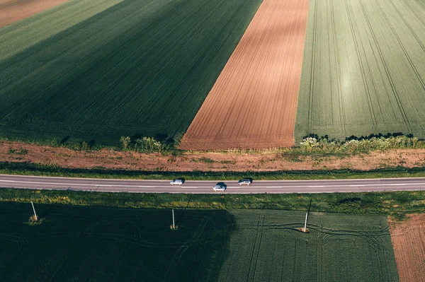 Три Автомобілі Рухаються Дорозі Через Сільський Пейзаж Сонячний Весняний День — стокове фото