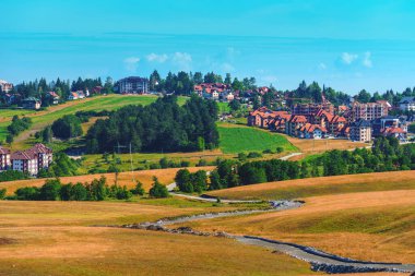 Apartment buildings on hills around Zlatibor region, famous tourist resort in Serbia on sunny summer morning