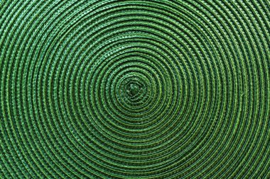 Texture of green plastic woven placemat on dining table, top view