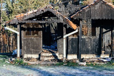 Yangından sonra yanan bir evin ahşap yapısı seçici bir odak noktası.