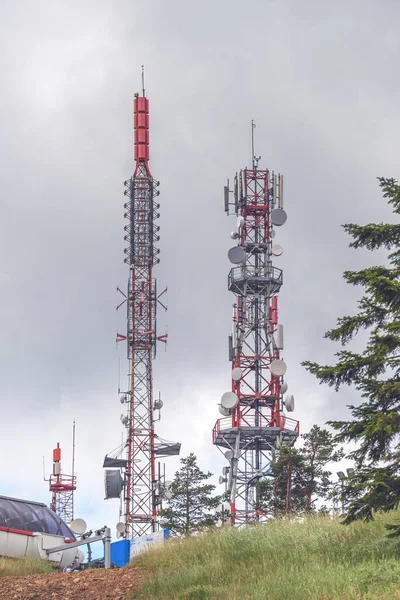 Telecommunication tower and mobile phone signal repeater at mountain top on overcast day