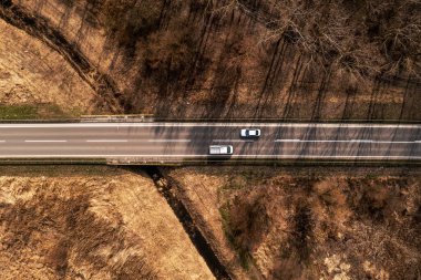 Sonbahar manzarası boyunca otoyoldaki araba ve kamyonun üst görüntüsü, İHA pov 'un tam üstünde.